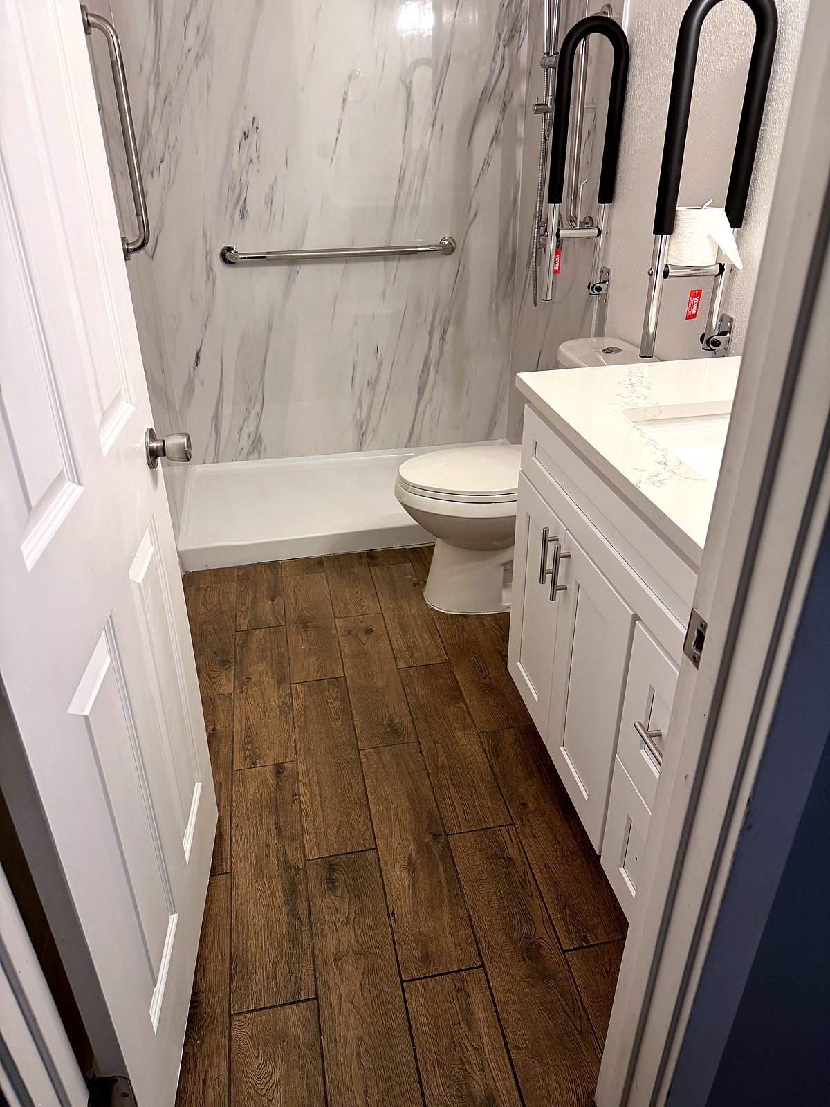 Bathroom renovation with wood-look tile and marble shower surround, King County.