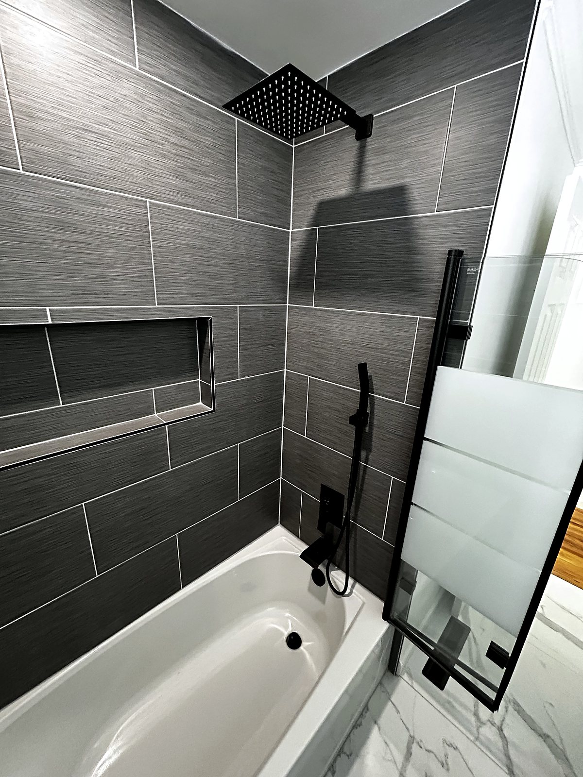 Dark gray textured tile shower with matte black fixtures, King County.
