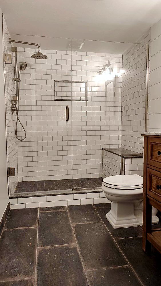 Walk-in glass shower with subway tile and slate-style flooring, King County.