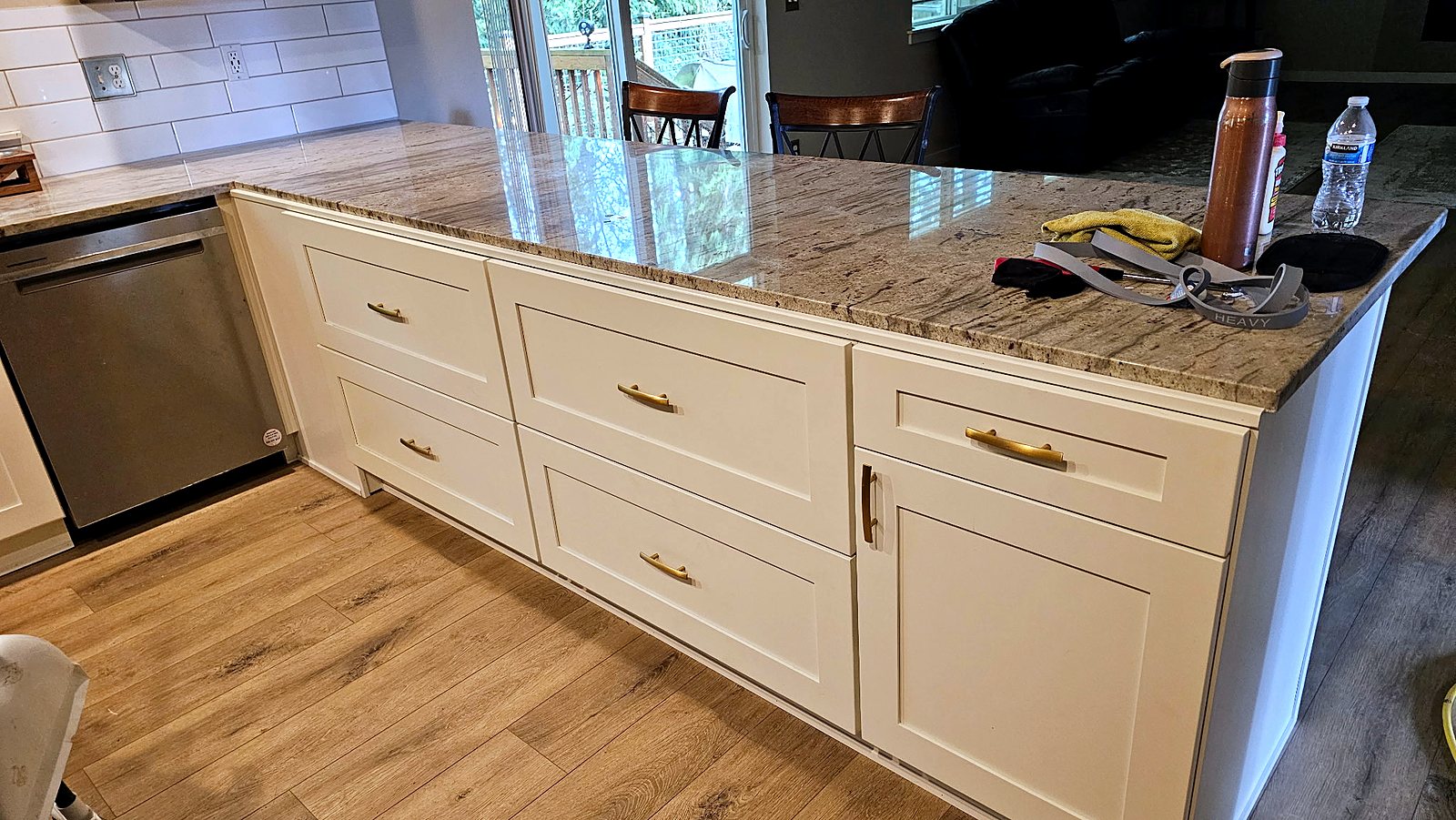 White shaker kitchen island with granite countertop and brass pulls, King County.