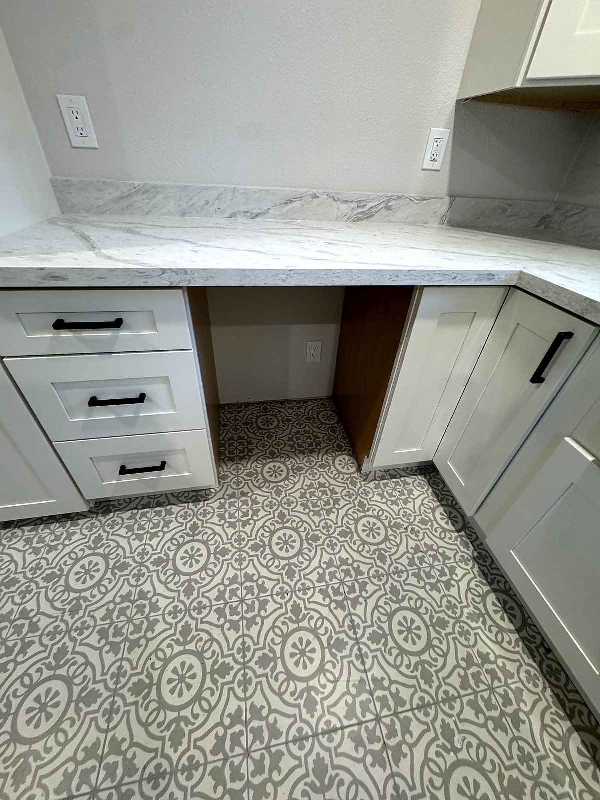 White shaker bathroom vanity with marble countertop and patterned tile, King County.