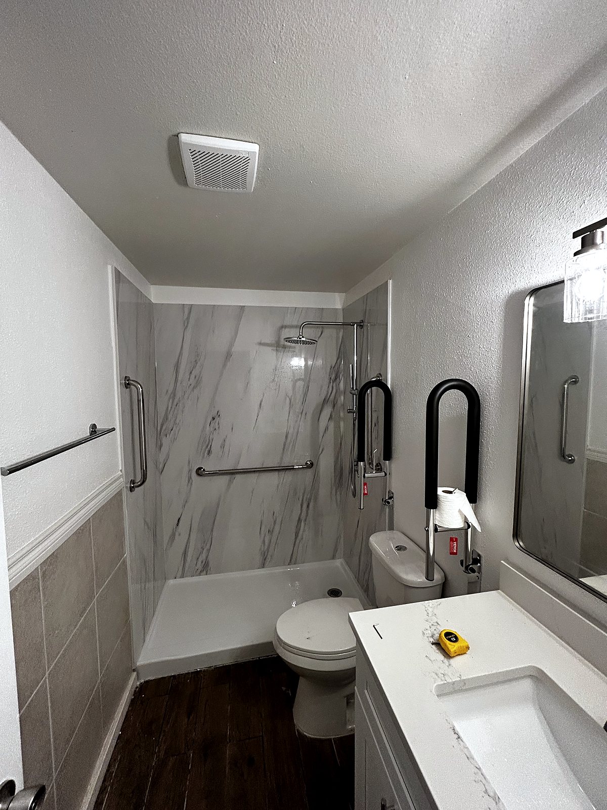 Bathroom renovation with marble shower panels and safety rails, King County.