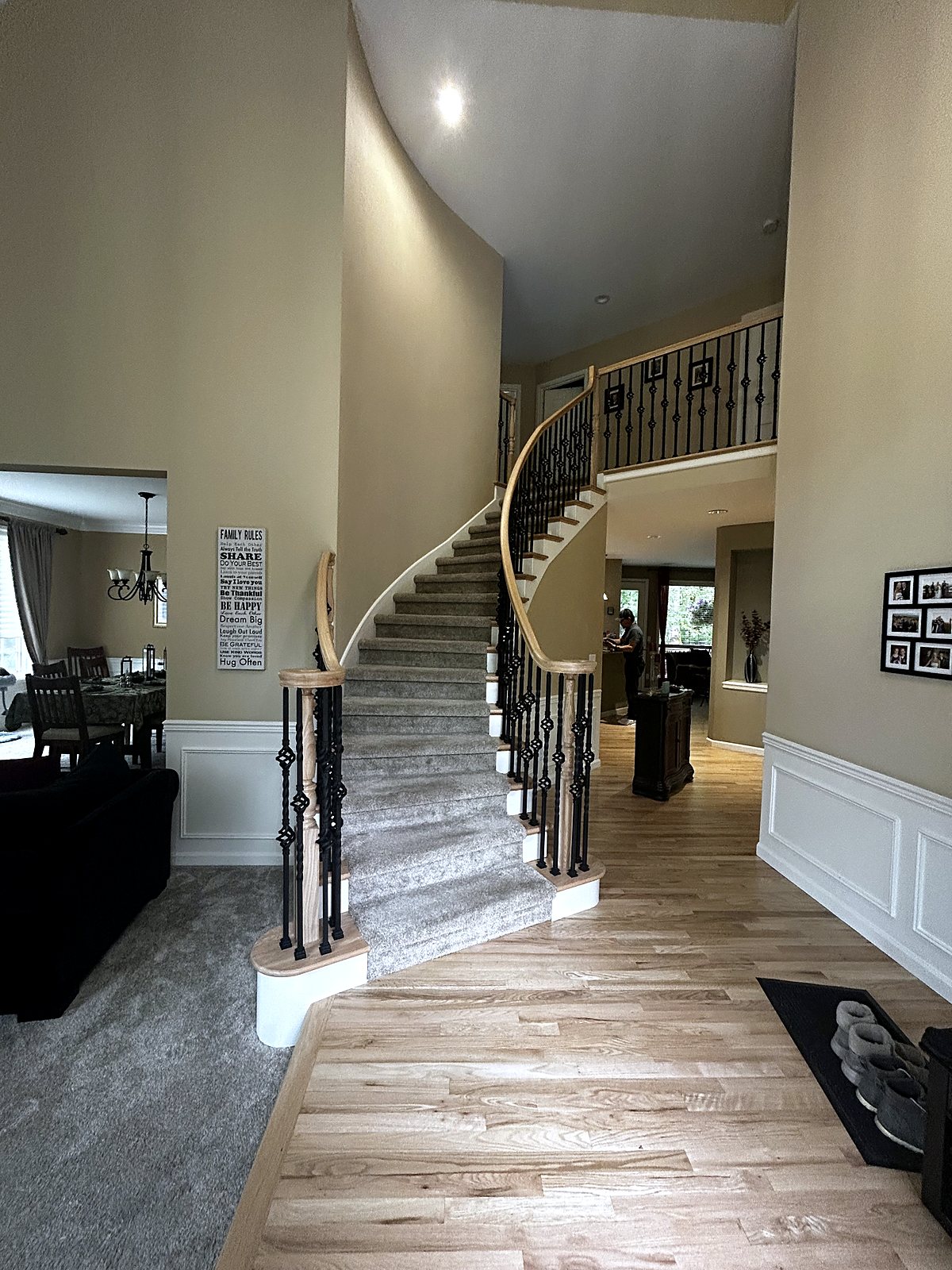 Custom curved staircase with oak handrails and iron balusters, King County.