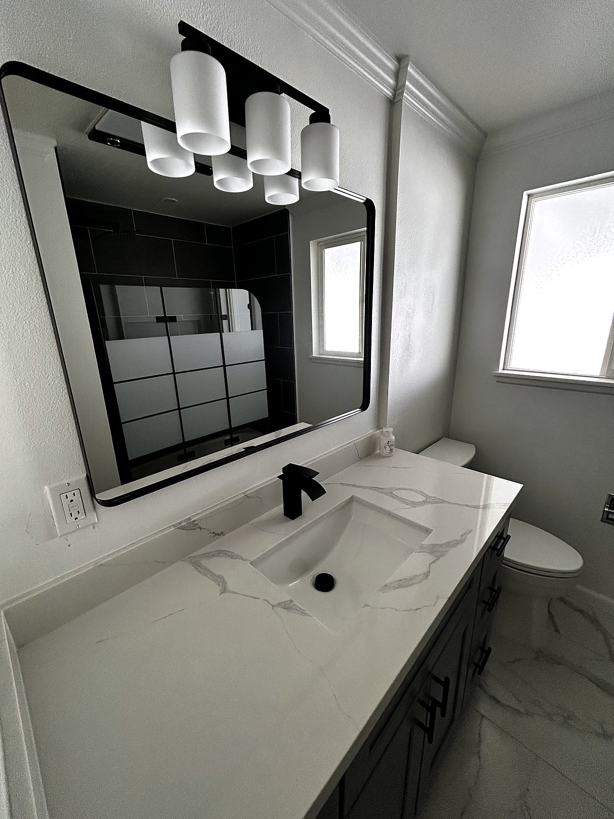 Modern bathroom vanity with quartz countertop and black fixtures, King County.