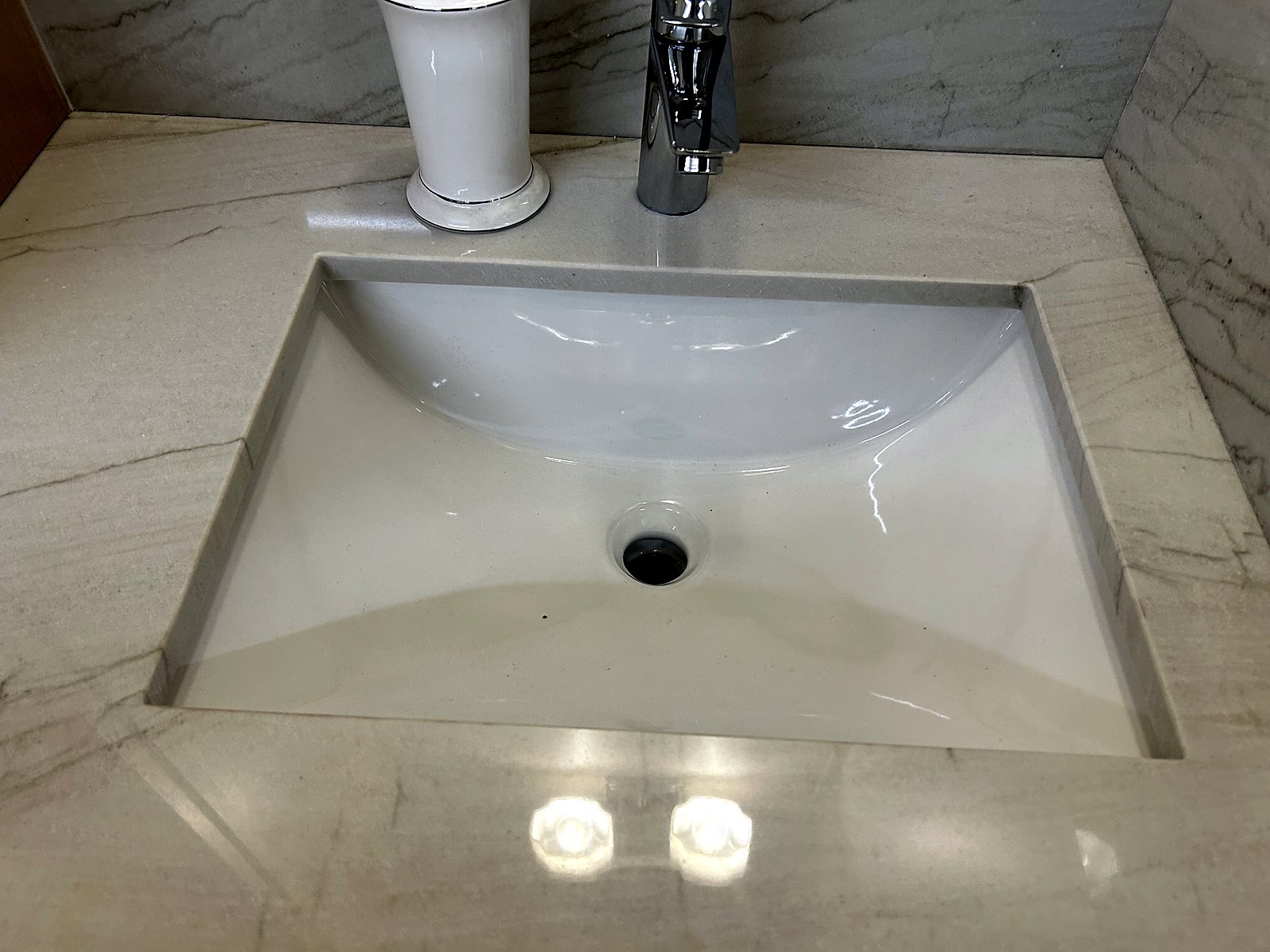 White undermount bathroom sink with chrome faucet, King County plumbing installation.