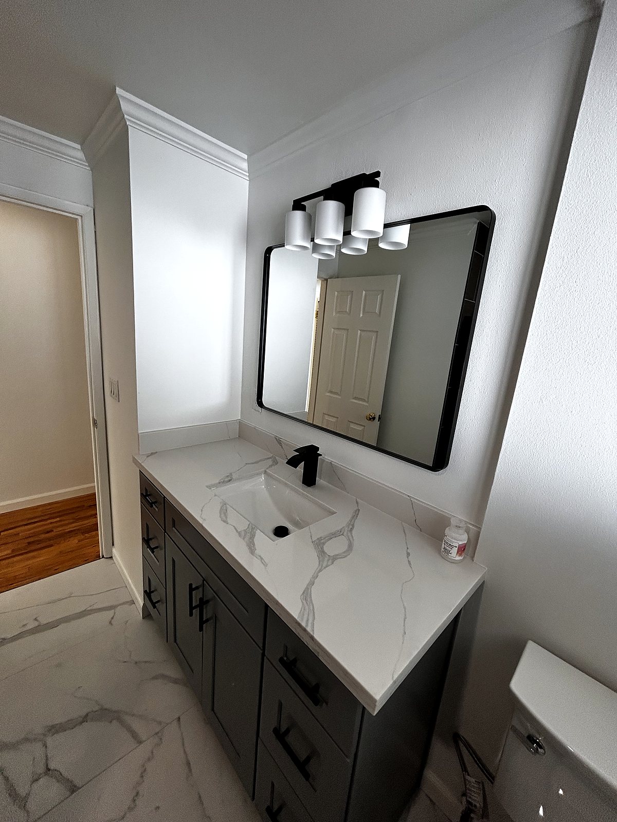 Renovated bathroom with gray vanity and marble-look tile, King County.