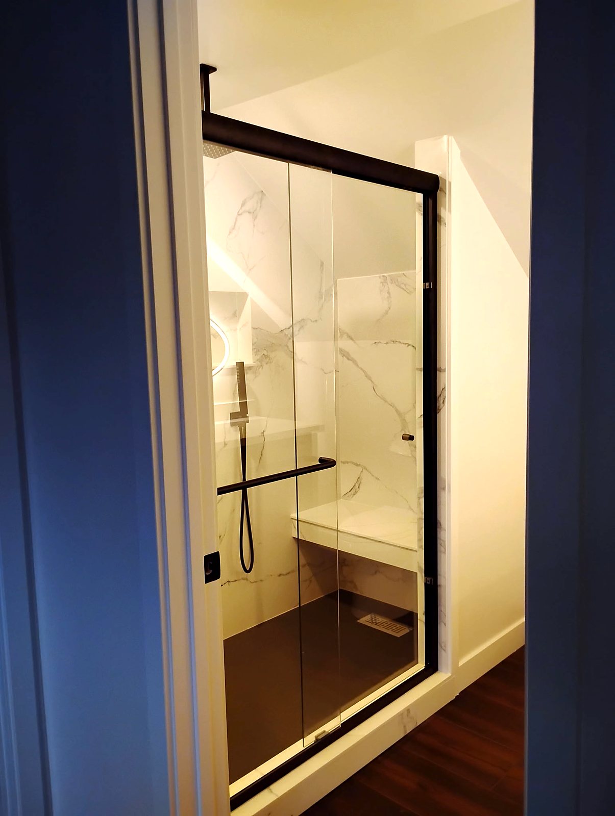 Walk-in shower with marble tile, matte black doors, King County bathroom remodel.