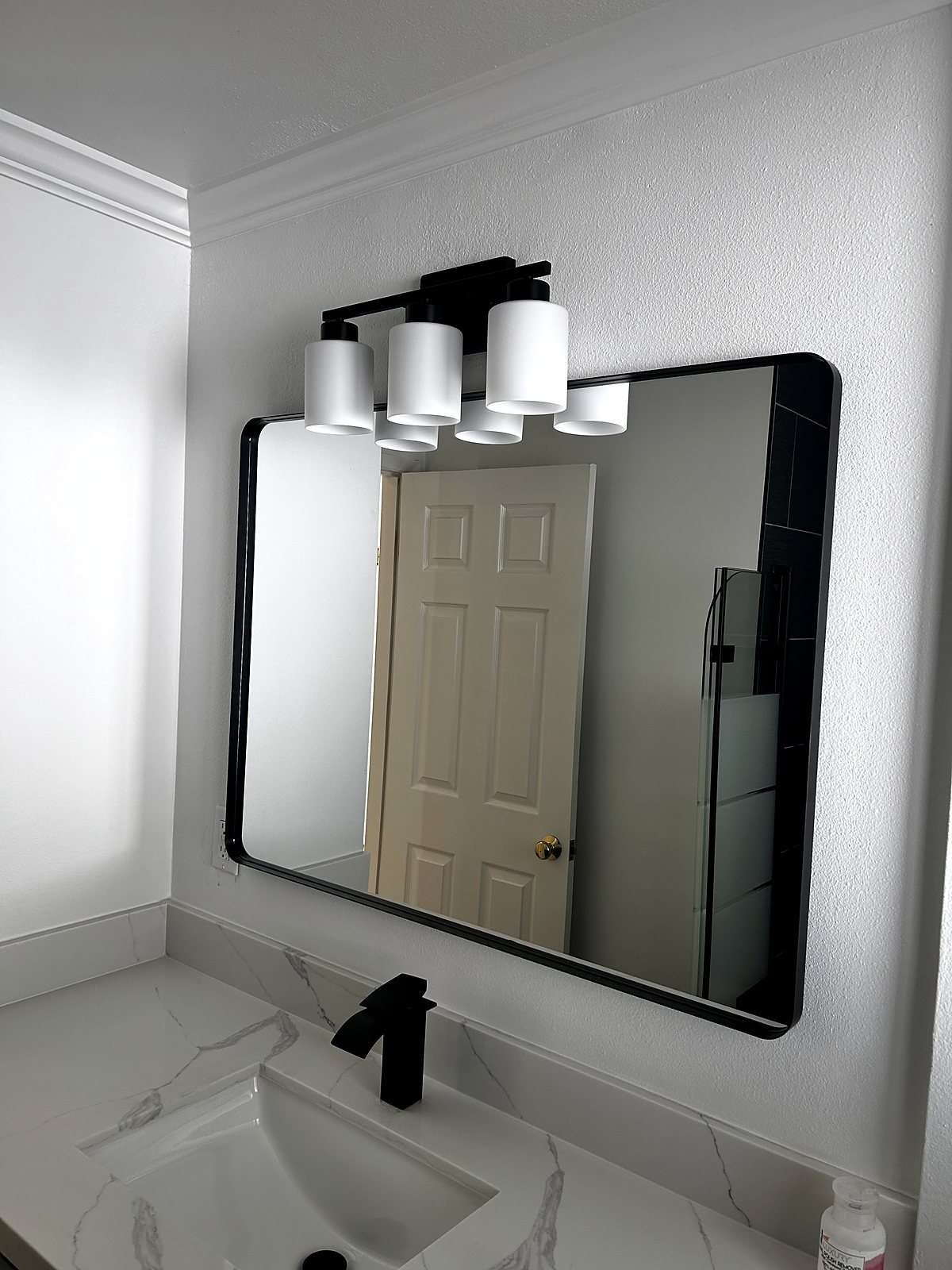 Bathroom vanity renovation with quartz countertop and black fixtures, King County.