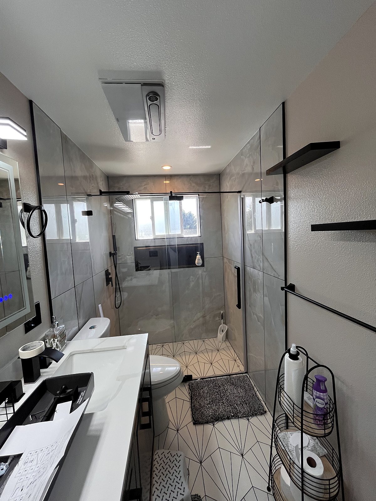Modern bathroom renovation with marble tile and frameless glass shower, King County.