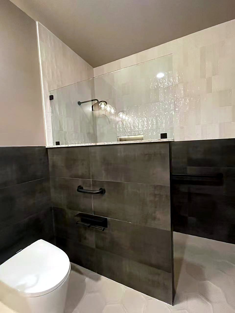 Modern bathroom renovation with dark charcoal tile and white zellige tile, King County.