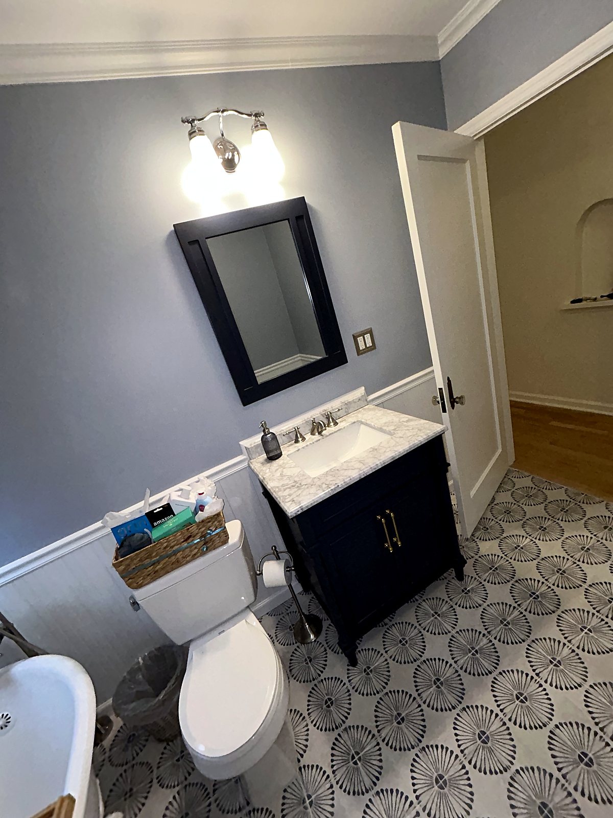 Navy bathroom vanity with marble countertop and black-white tile flooring, King County.