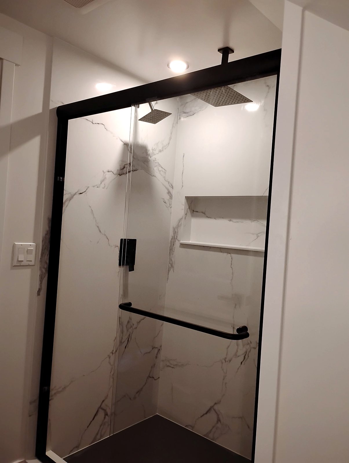 Walk-in shower renovation with marble tile and matte black fixtures, King County.