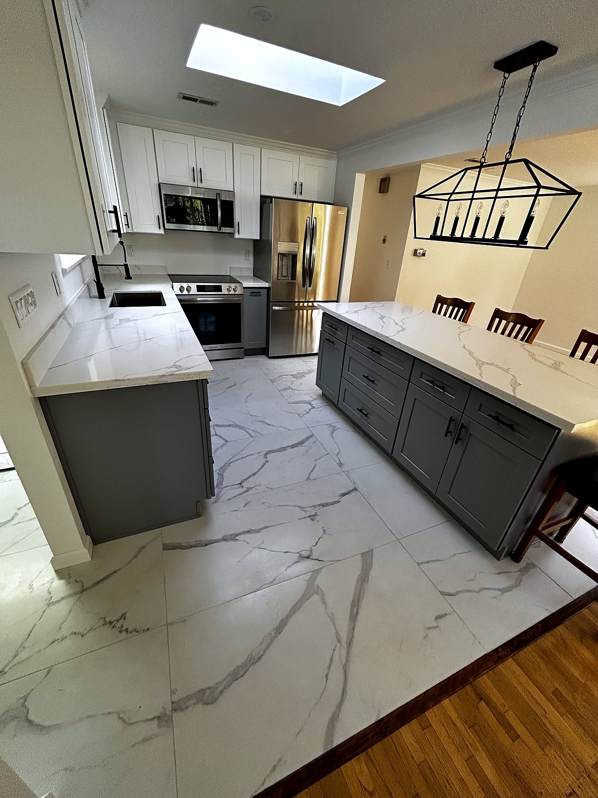 Renovated kitchen with marble tile, gray cabinets, stainless appliances, King County.